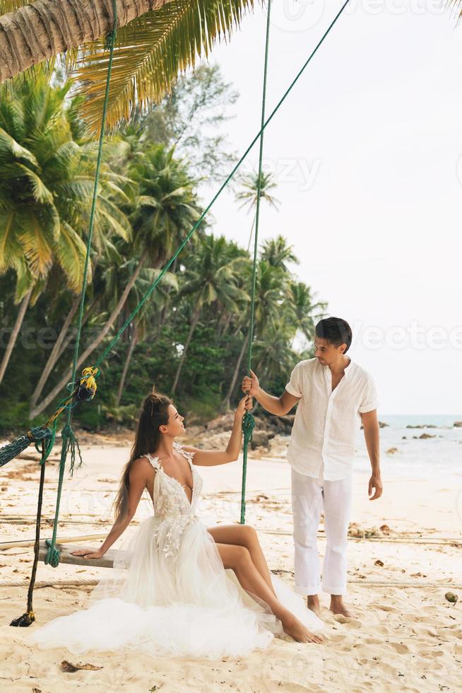 Happy young married couple celebrating their wedding on the beach photo