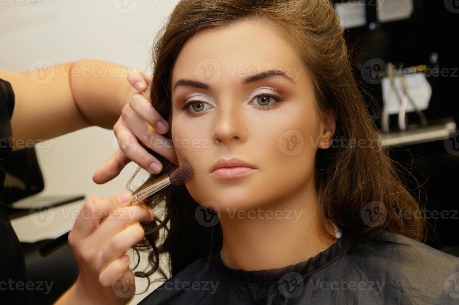 Model and makeup artist working before photoshoot photo