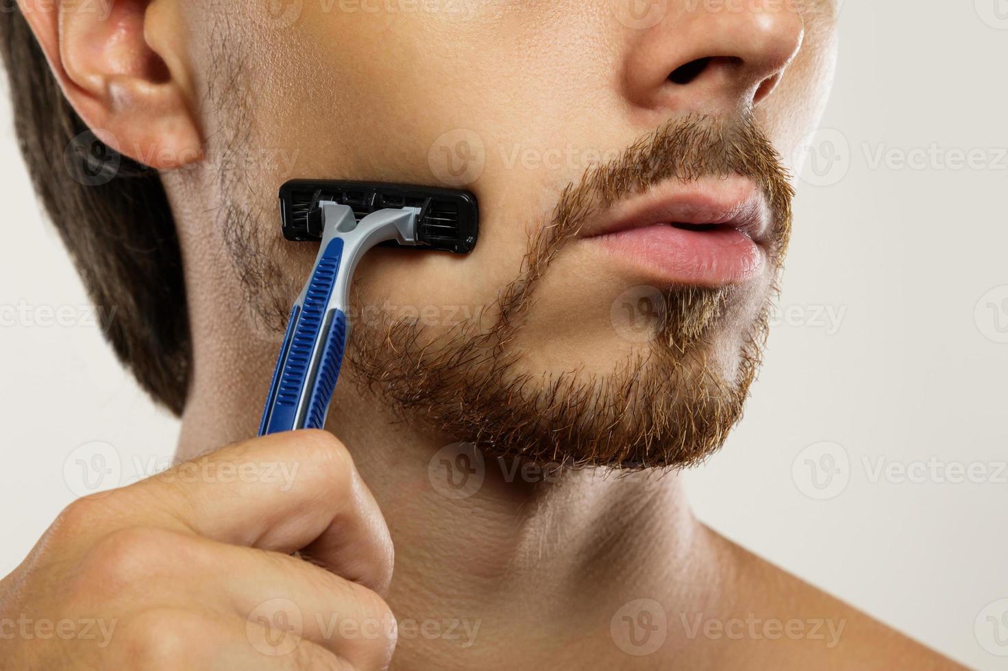 Man during shaving routine with a safety razor photo