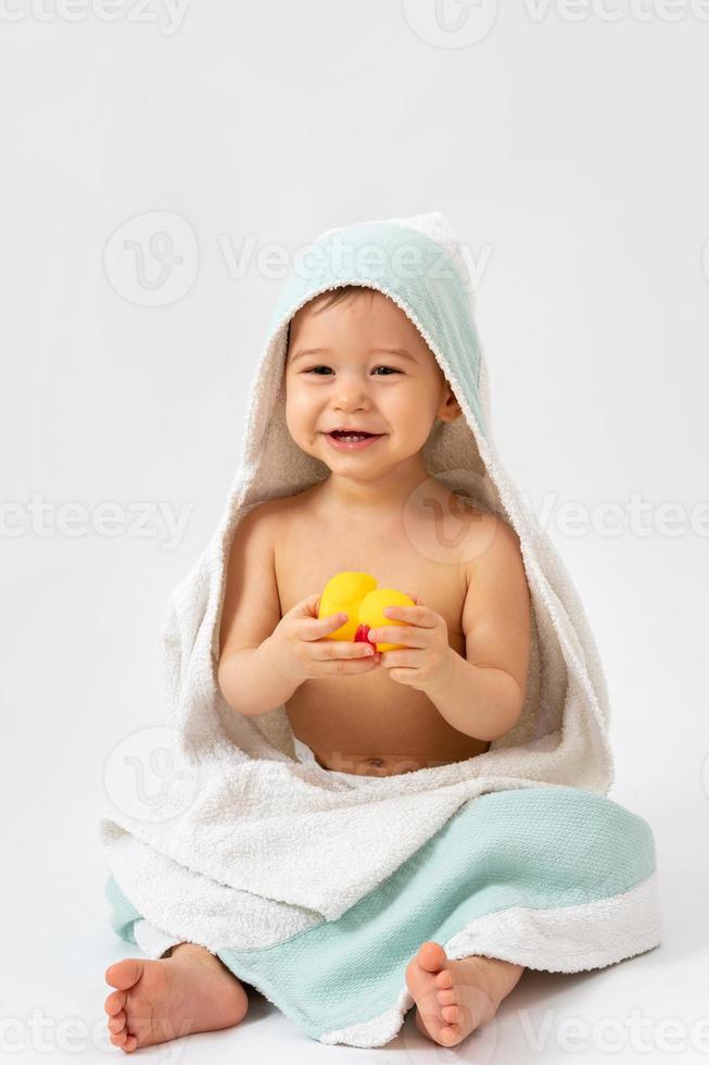 Cute baby wrapped into hooded towel after a bathing photo