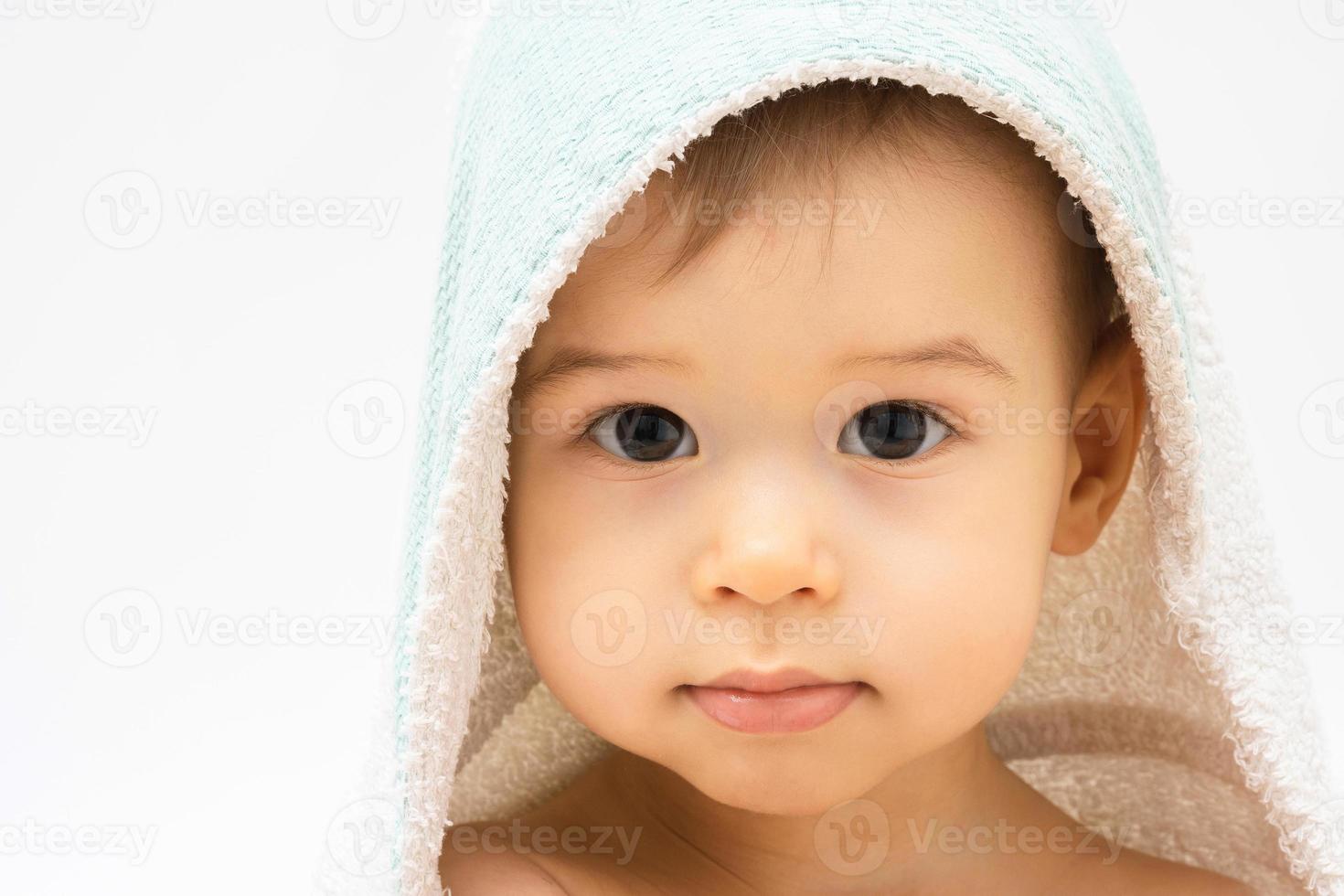 Cute baby wrapped into hooded towel after a bathing photo