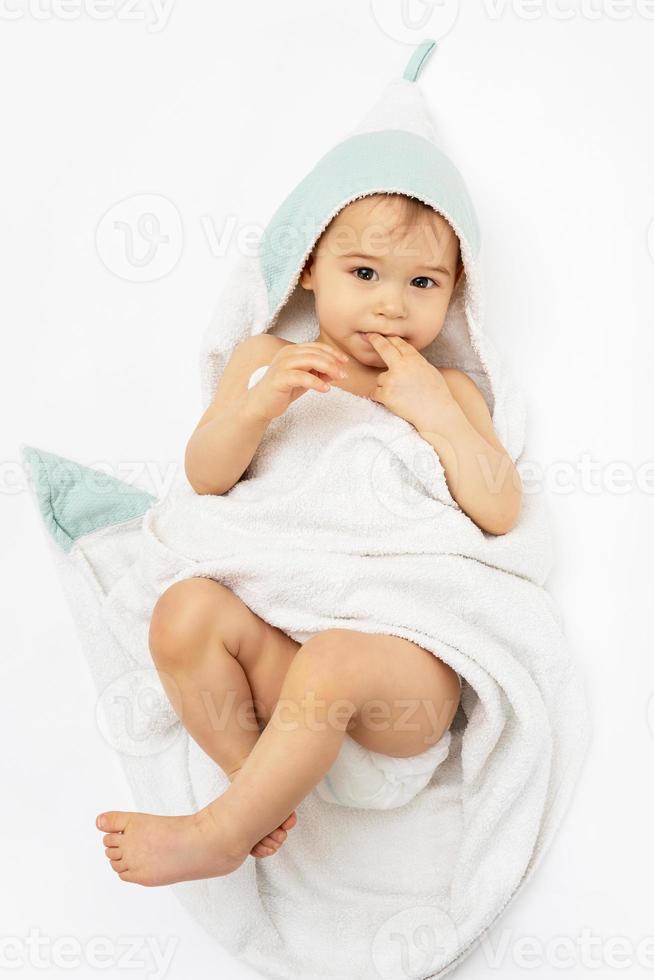 Cute baby wrapped into hooded towel after a bathing photo