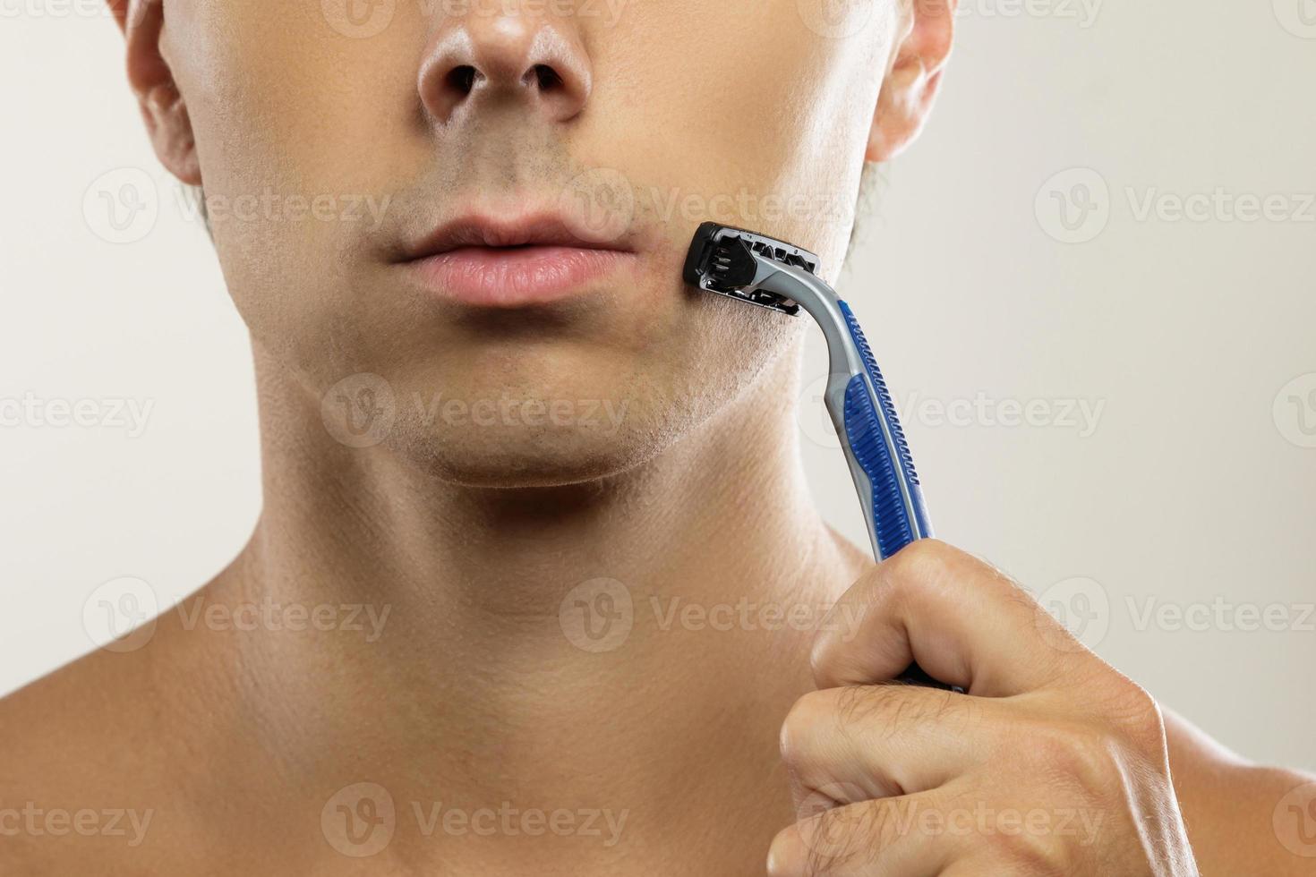 Man during shaving routine with a safety razor photo