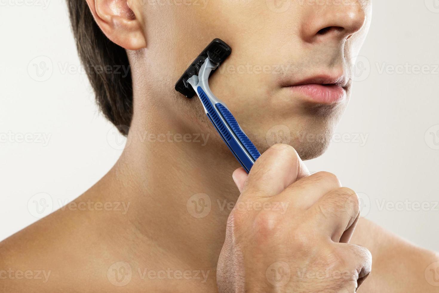 Man during shaving routine with a safety razor photo