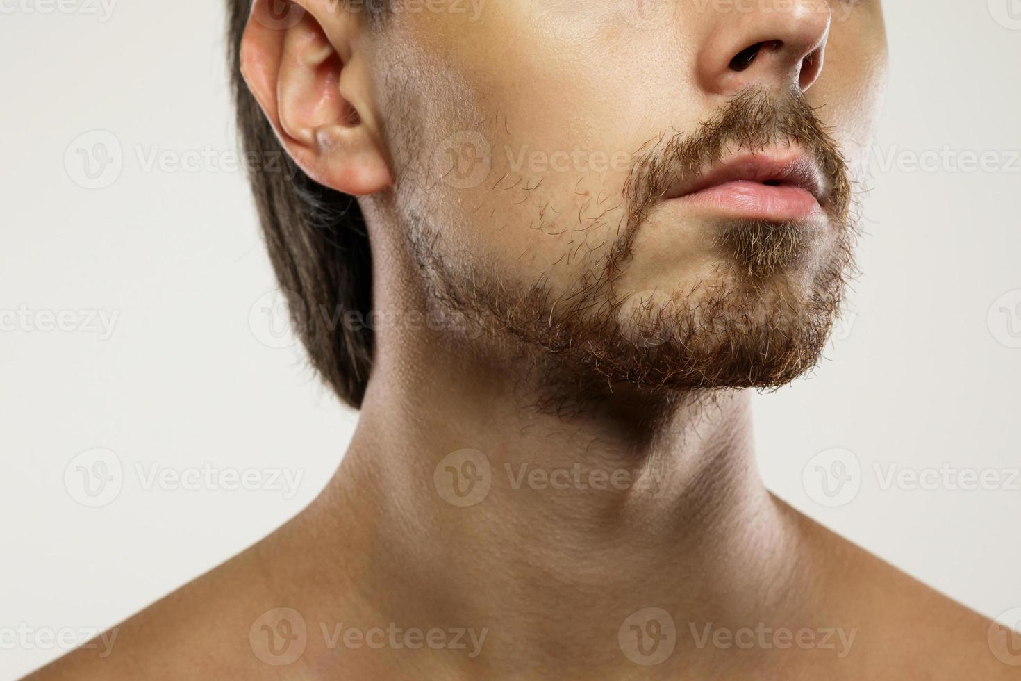 Closeup of male face with unshaved man with a unkempt beard photo