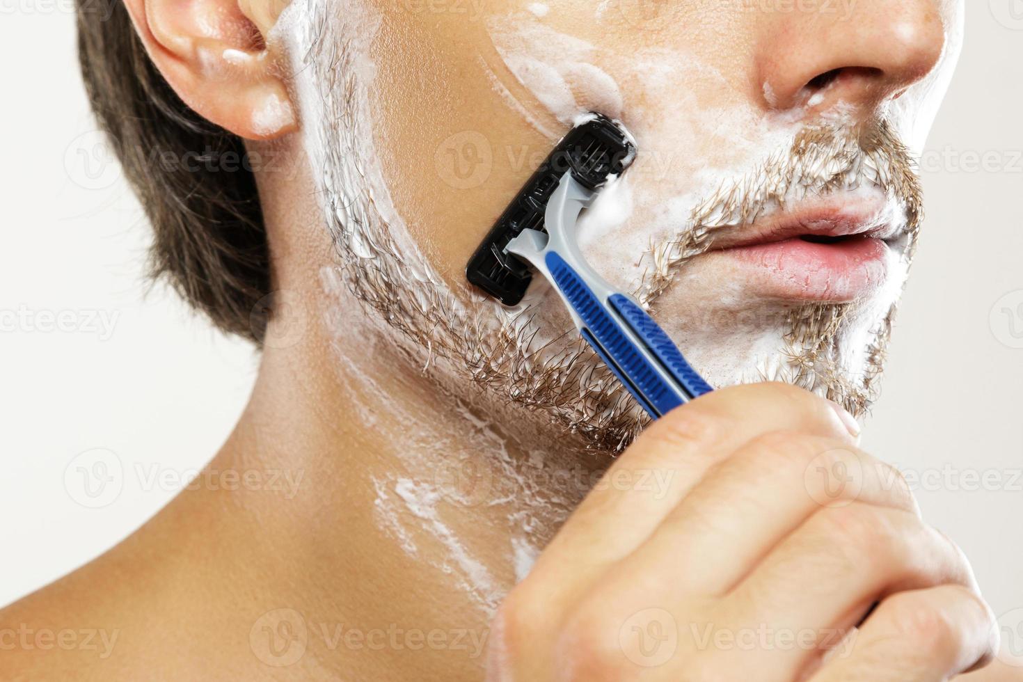 Man with a safety razor and shaving cream on his face 16234023 Stock