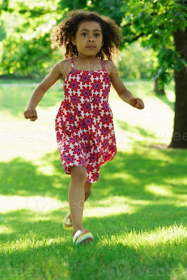 Running cute black girl in a city park photo