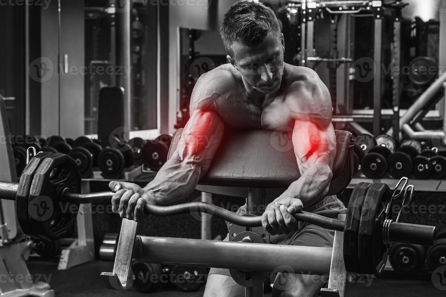 Man in gym during specialization for biceps in a bodybuilding photo