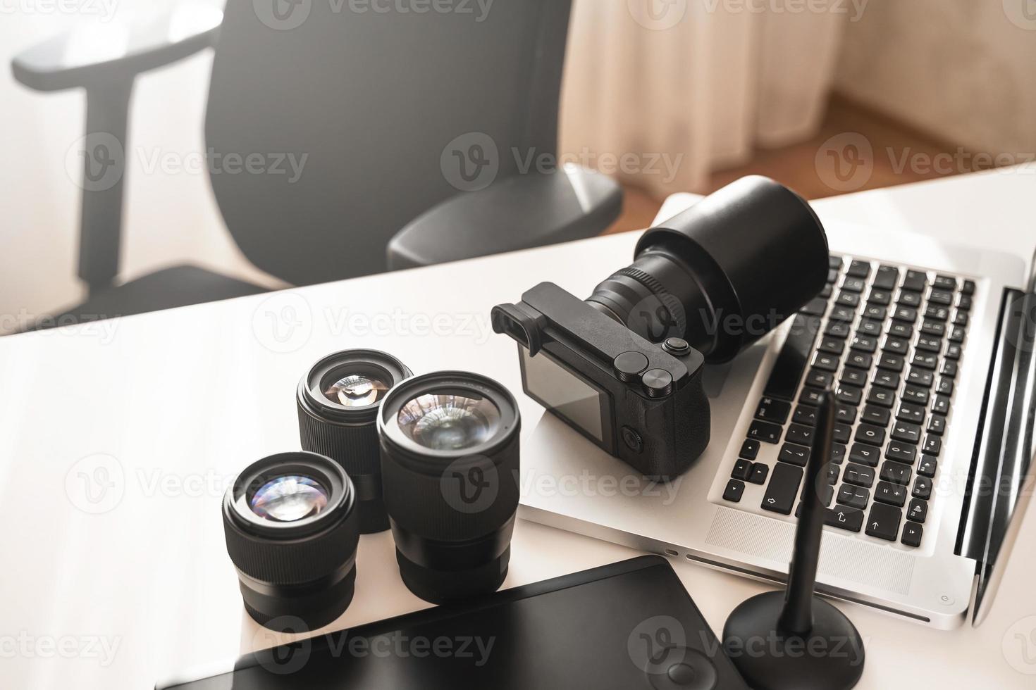 Workplace with a modern equipment for photography. Mirrorless camera and prime lenses. photo