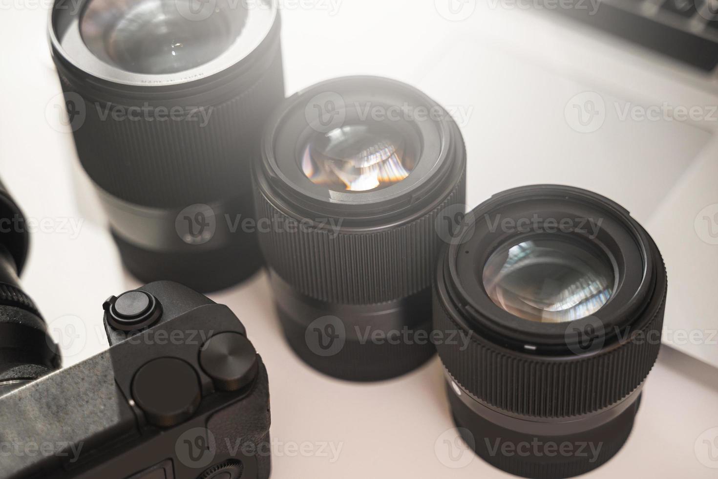 Workplace with a modern equipment for photography. Mirrorless camera and prime lenses. photo