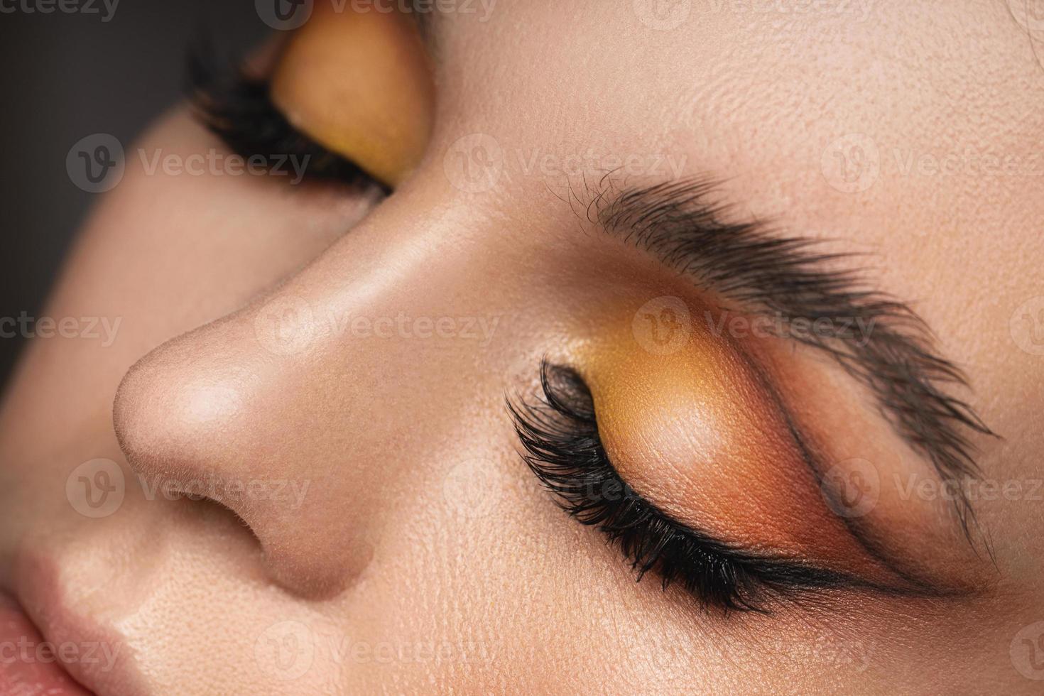 ojos femeninos con una sombra de ojos colorida y laminación de cejas foto