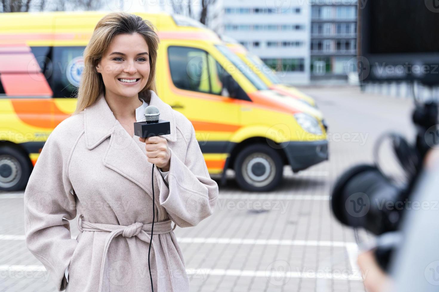 Smiling news reporter speaking into a microphone photo