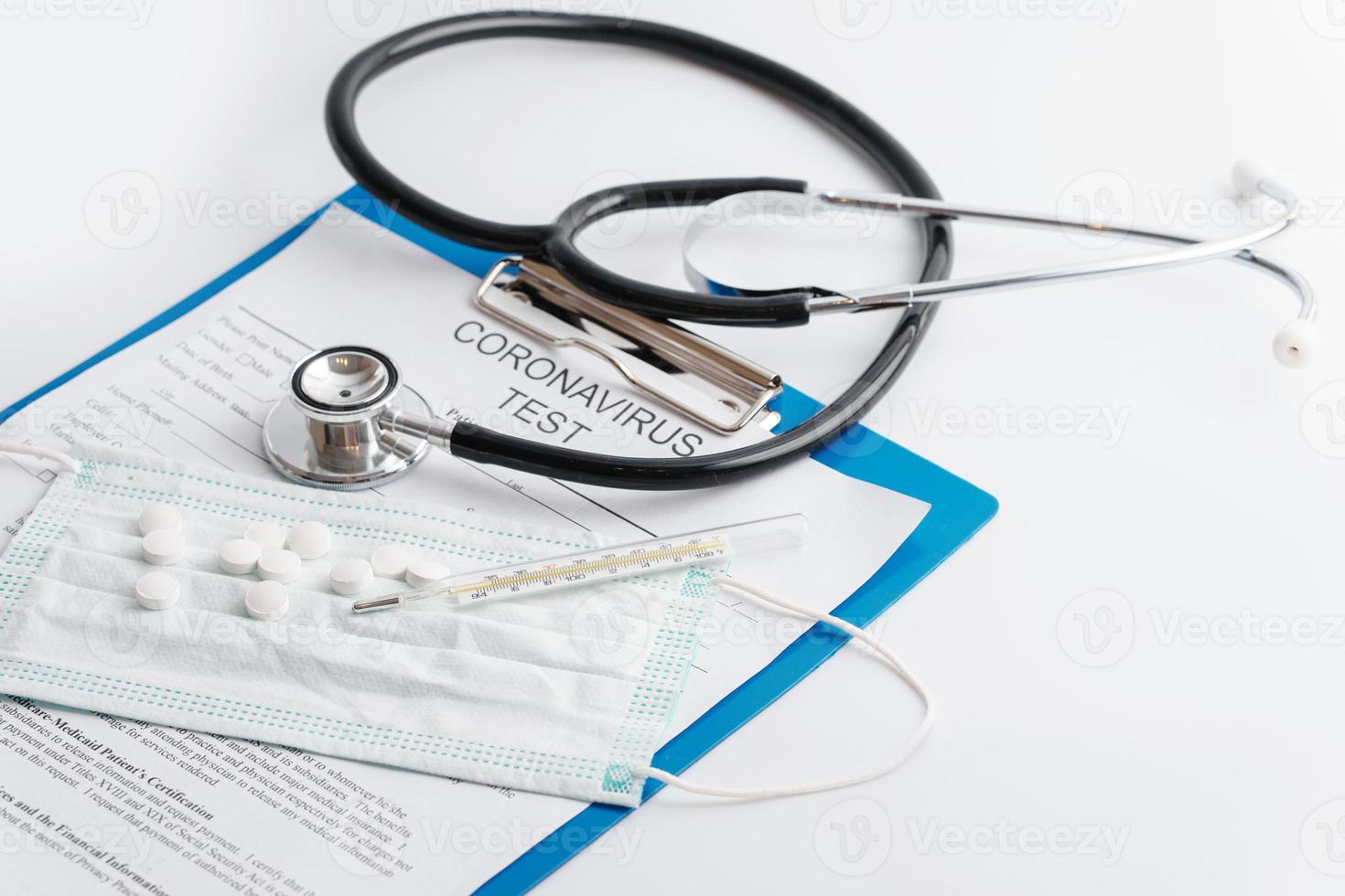 Stethoscope, thermometer and folder with documents on the table photo