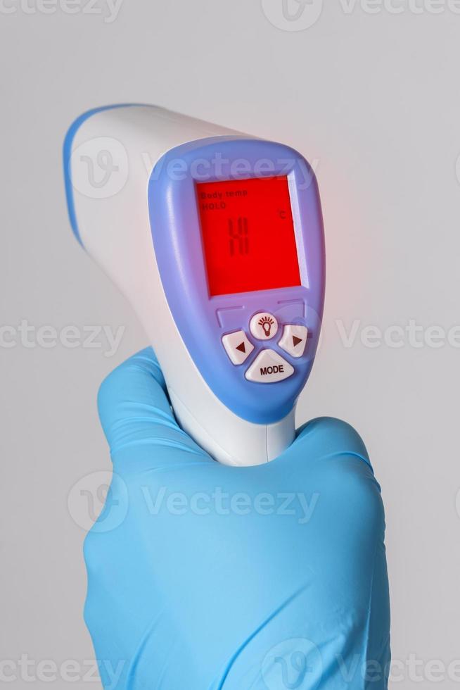 Doctor is holding a digital infrared thermometer photo