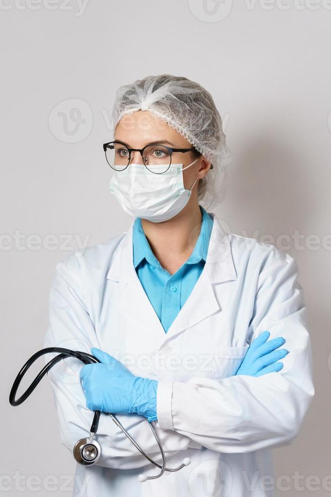 Female doctor with a stethoscope on gray background photo