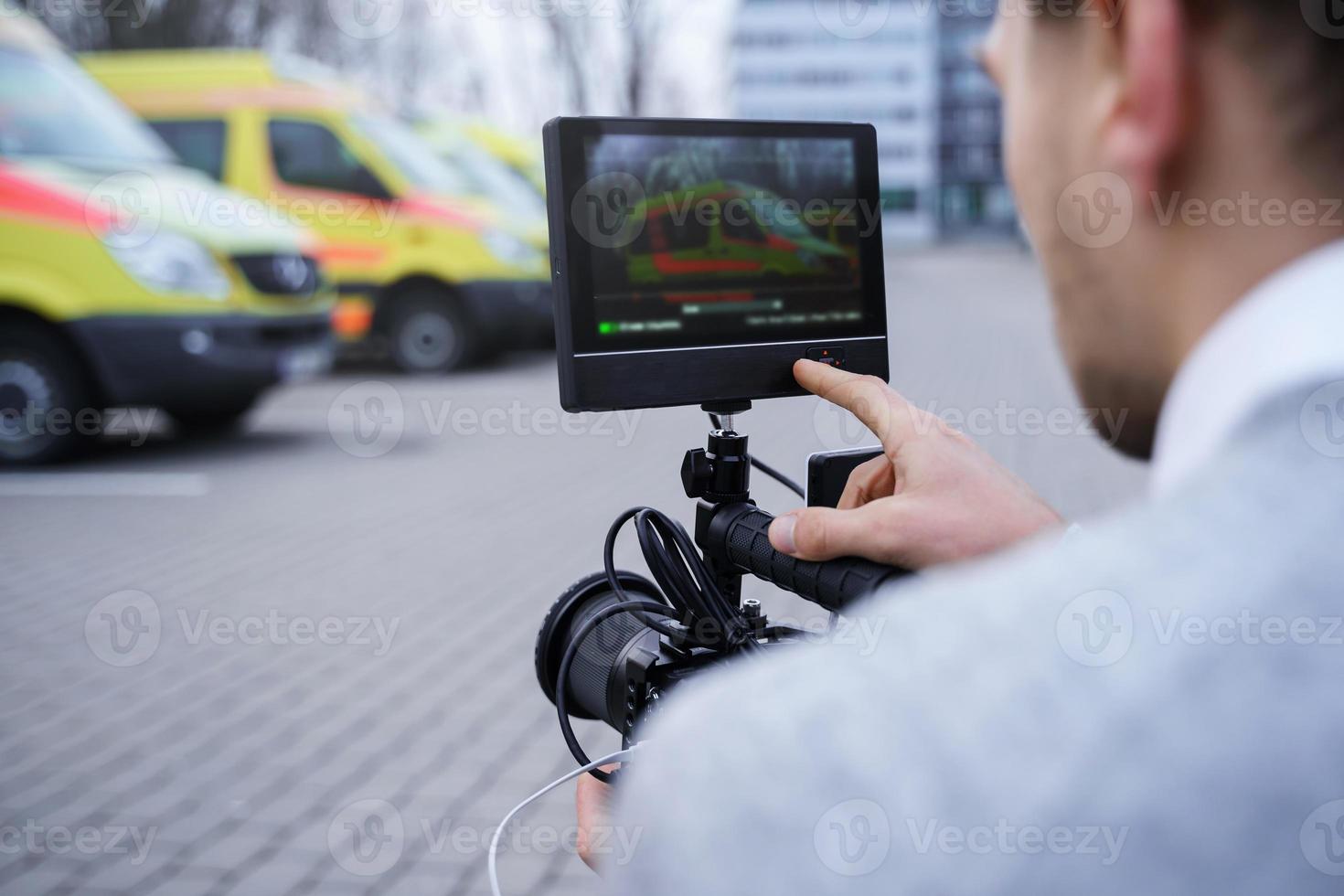 el camarógrafo está filmando noticias cerca de vehículos de ambulancia foto