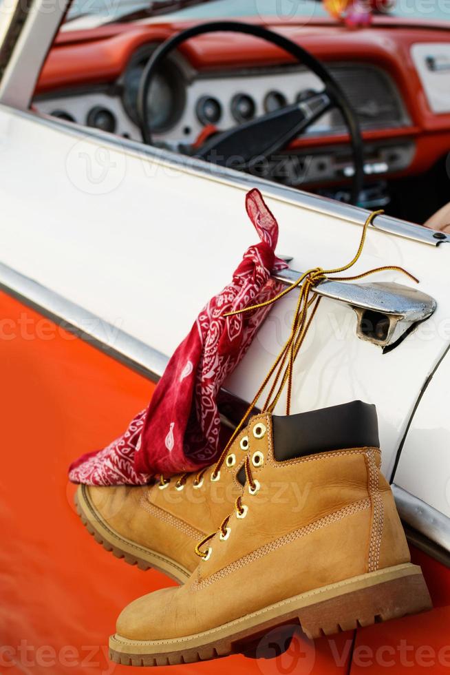 Retro car with tied boots and bandana to a door handle photo