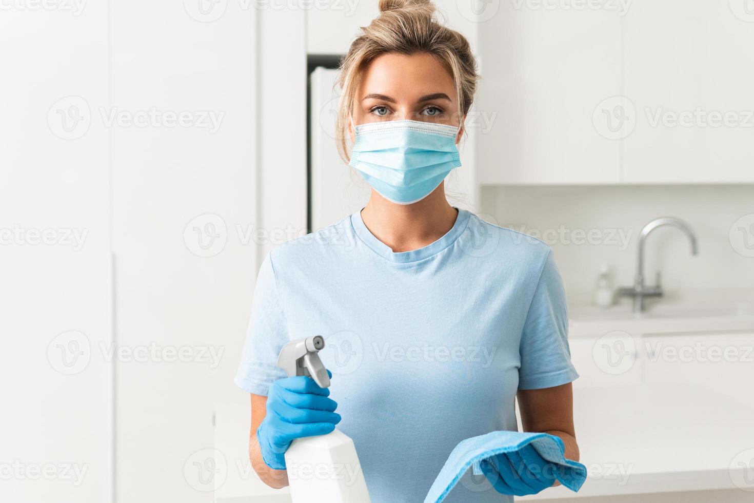 trabajadora con máscara de prevención y guantes durante la limpieza del apartamento foto