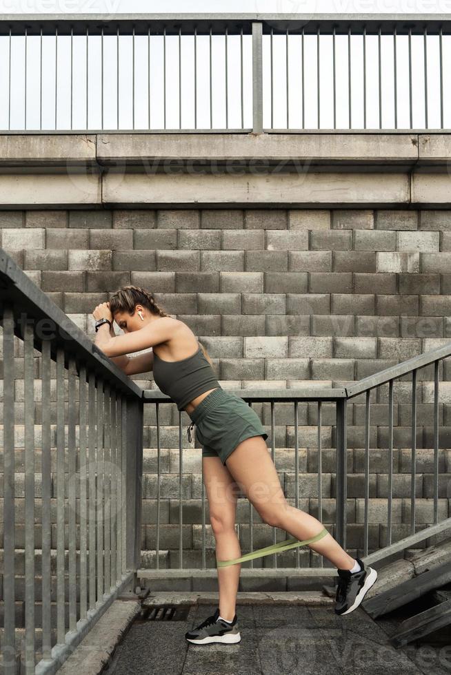 Athletic woman during workout with a resistance rubber band photo