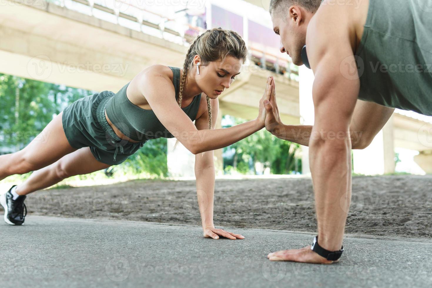 pareja atlética y entrenamiento físico al aire libre. hombre y mujer haciendo ejercicio de flexiones. foto