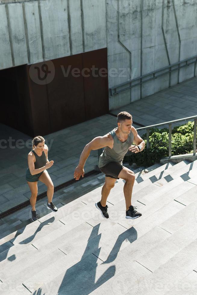 pareja deportiva durante la escalera de entrenamiento corriendo al aire libre foto