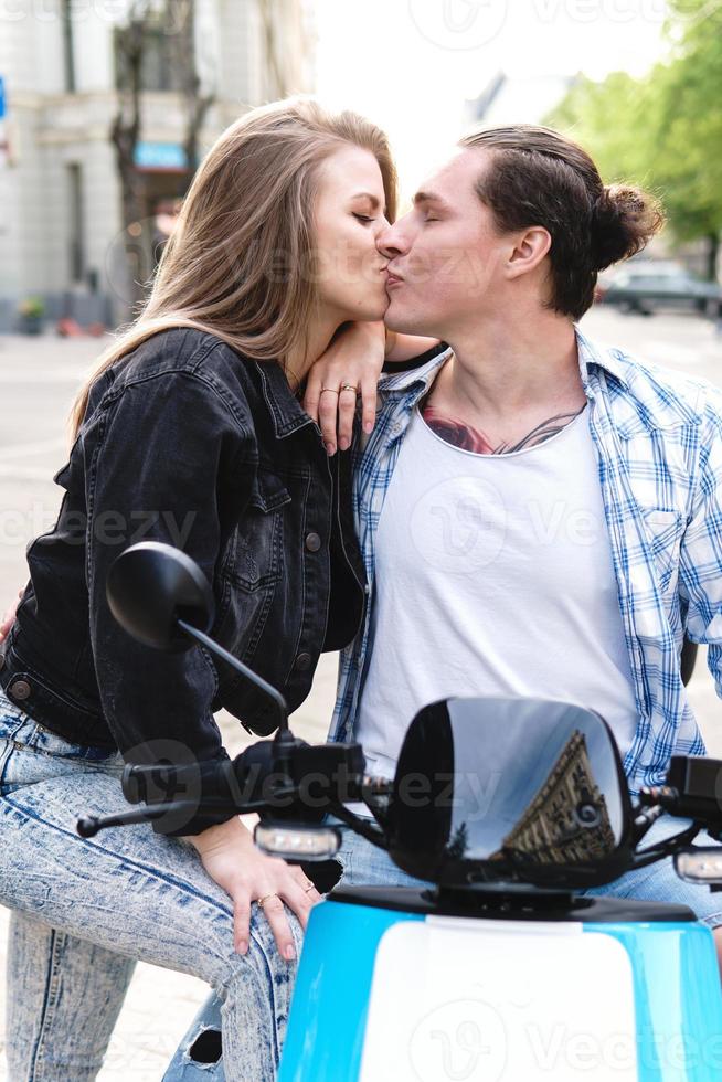 pareja elegante con una motocicleta en una calle de la ciudad foto