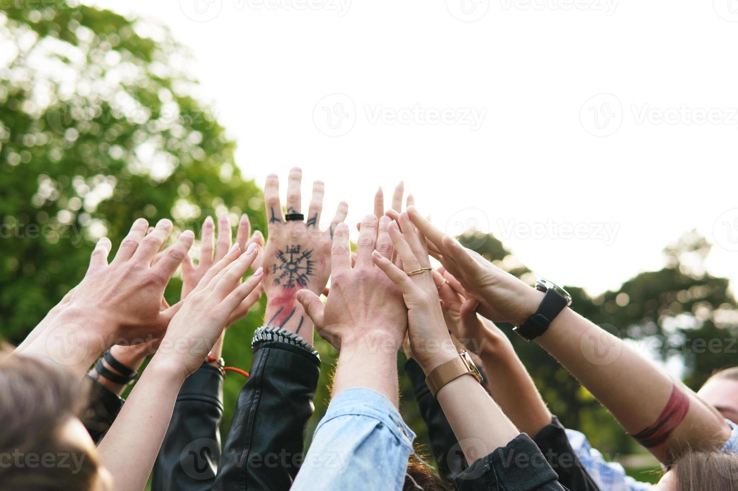 grupo de jóvenes levantando las manos en el aire foto