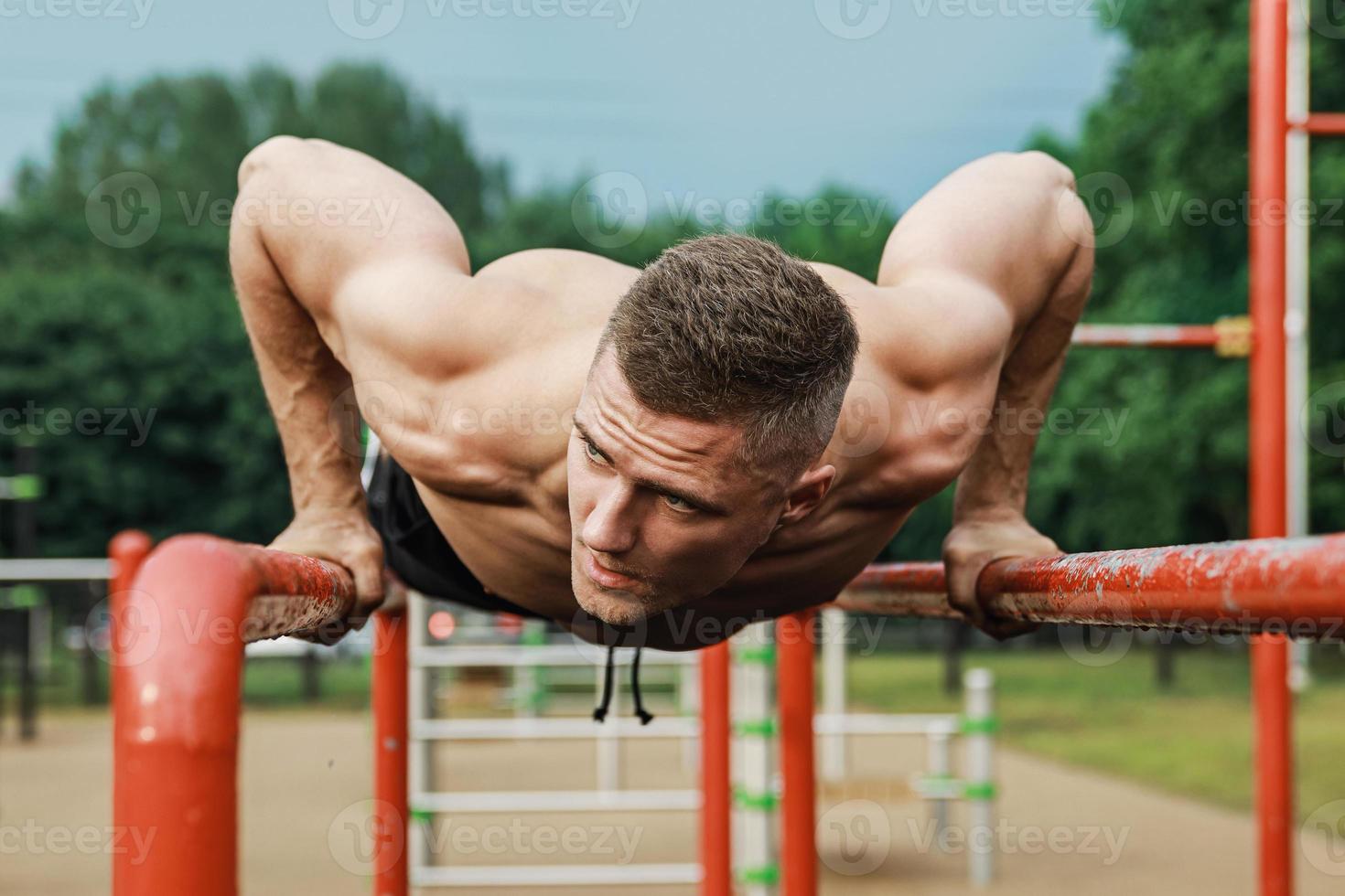 Muscular man during his workout on the street photo