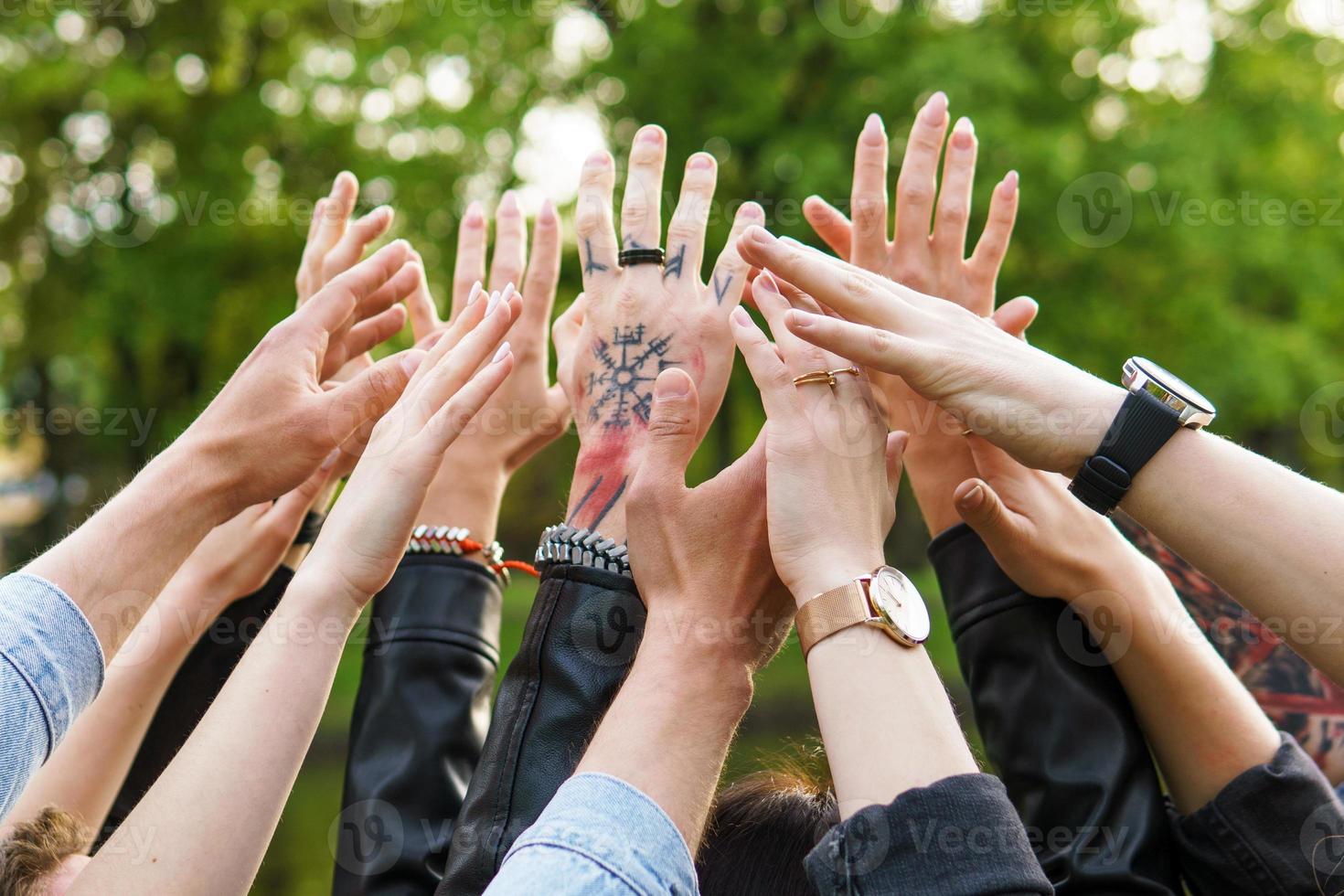 Group of young people putting hands up in the air photo