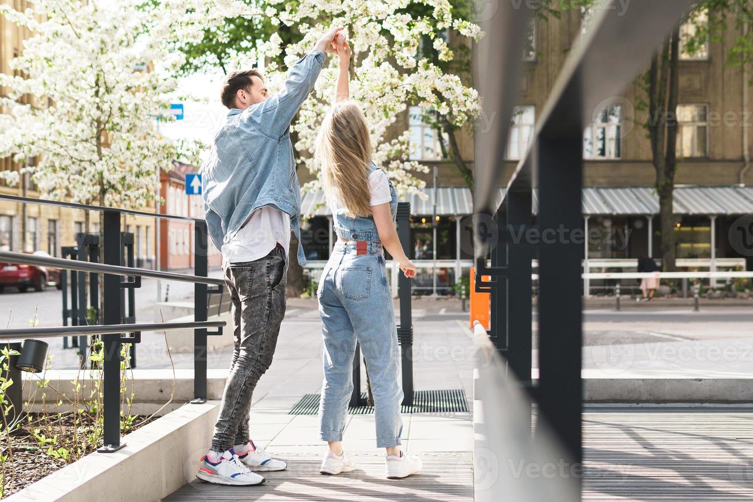 Young sensual and loving couple dancing during their date on a city street photo