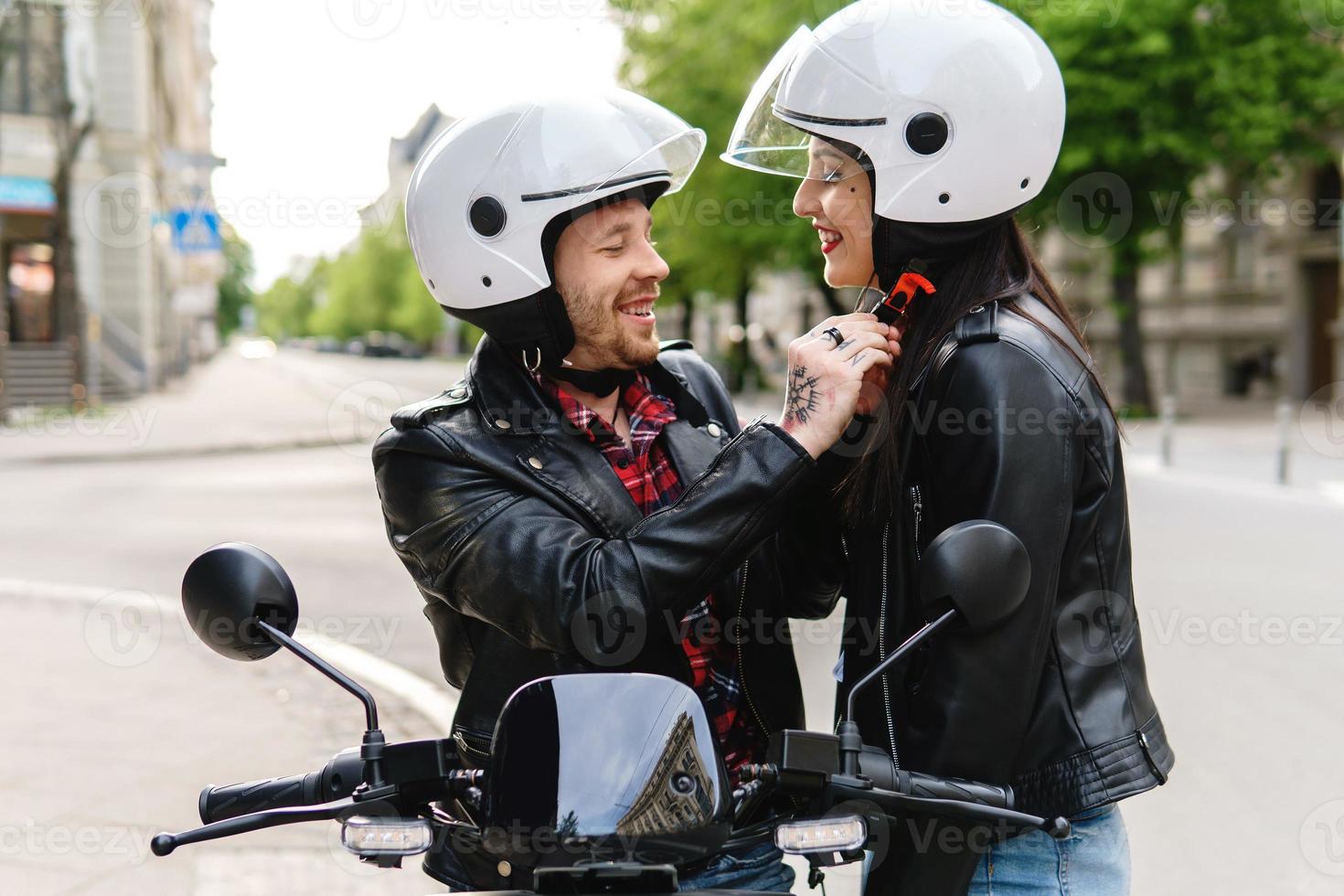 Stylish couple wearing motorcycle helmets before ride on electric scooter photo