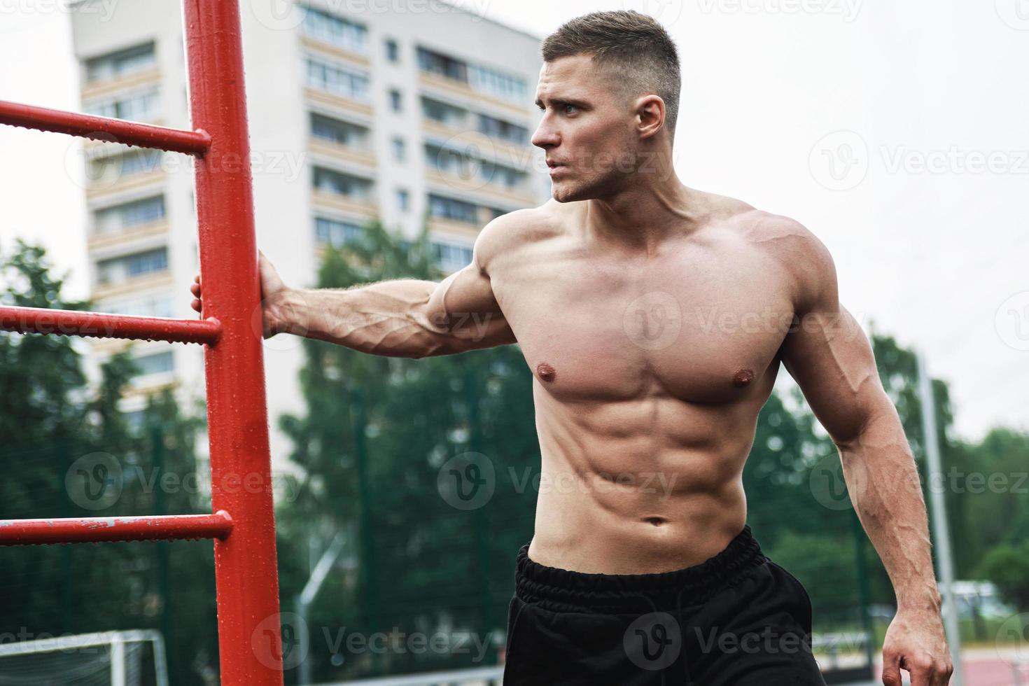 Muscular man during his workout on the street photo