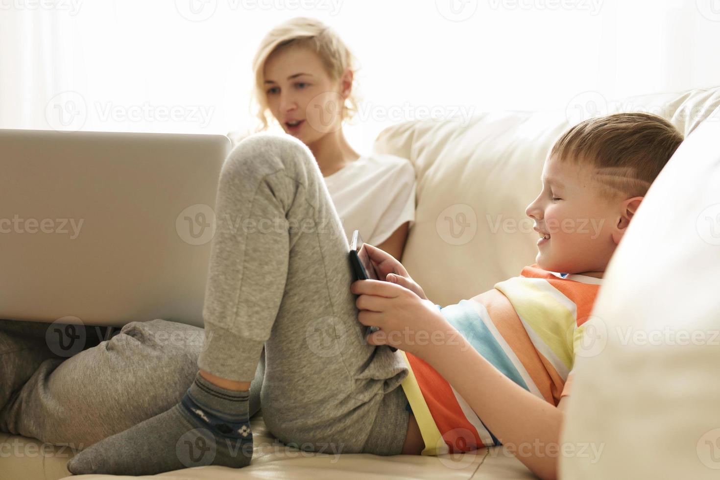 Boy is learning how to use a tablet pc at home photo