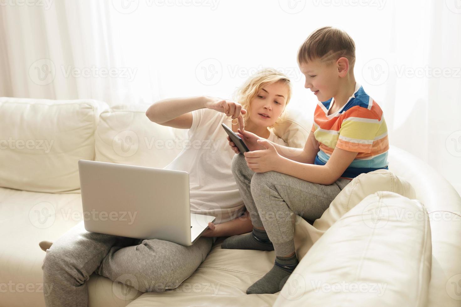 Boy is learning how to use a tablet pc at home photo