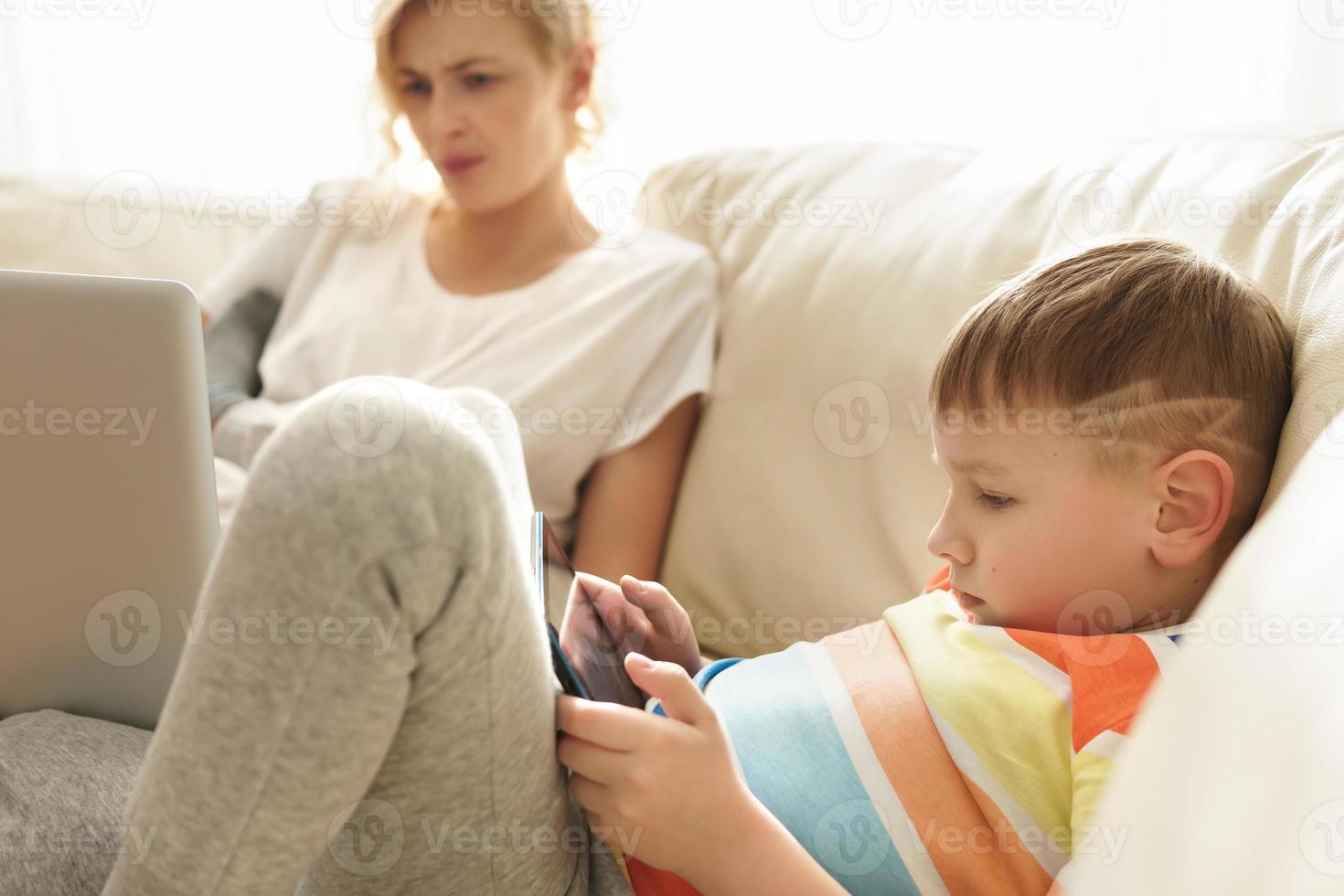 Boy is learning how to use a tablet pc at home photo