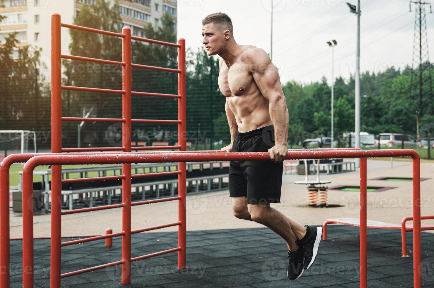 Muscular man during his workout on the street photo