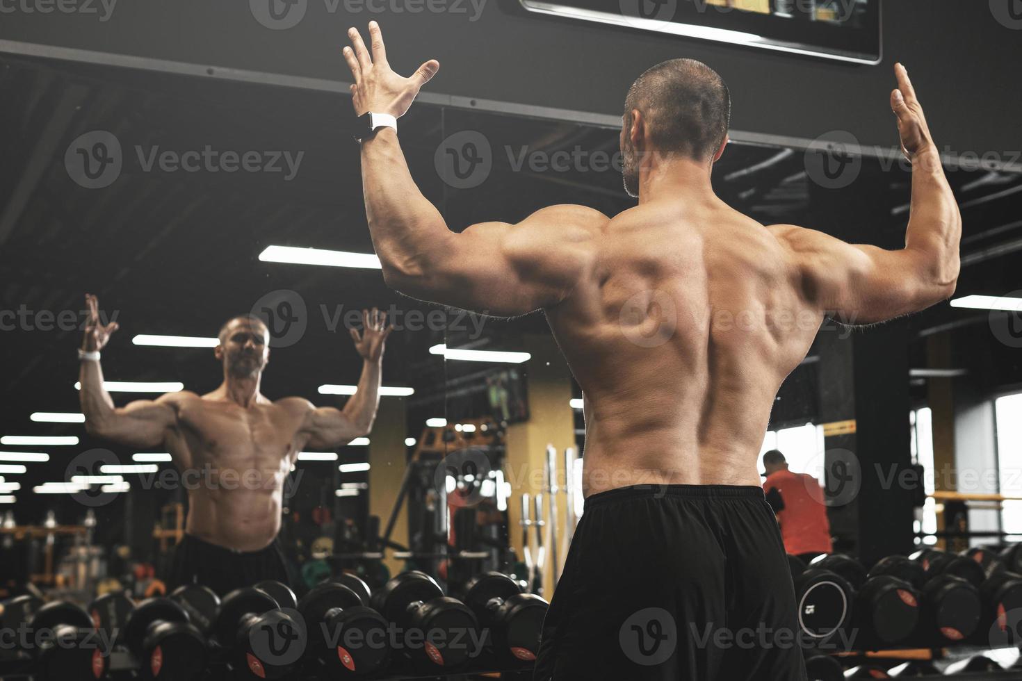Muscular bodybuilder in a free weights zone in the gym photo