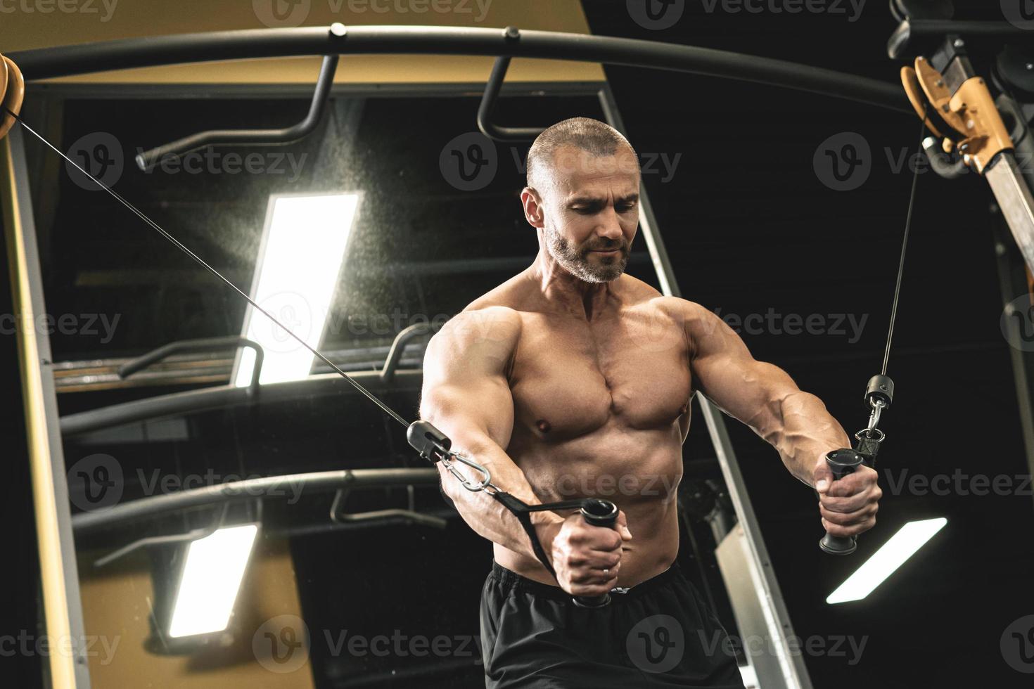 Muscular bodybuilder during his workout in the gym photo