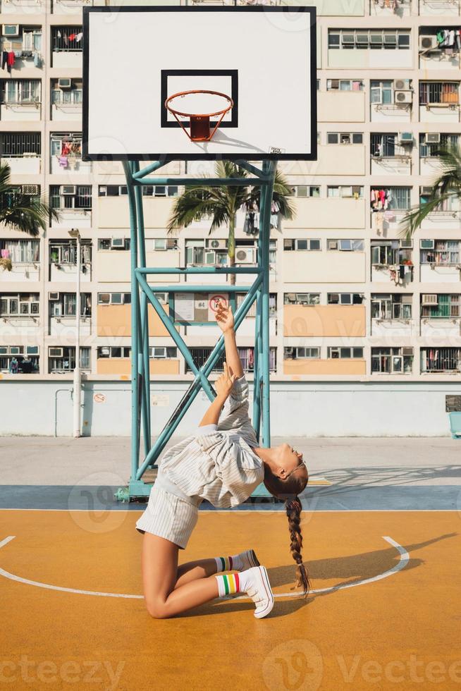 Young stylish woman is posing on the Choi Hung Estate Basketball Court photo