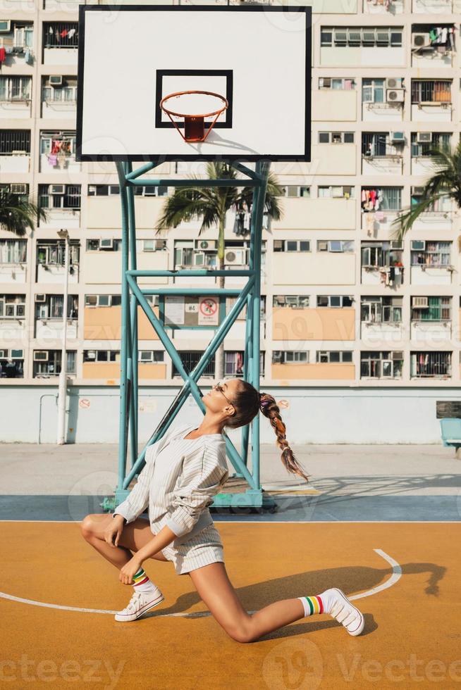 Young stylish woman is posing on the Choi Hung Estate Basketball Court photo