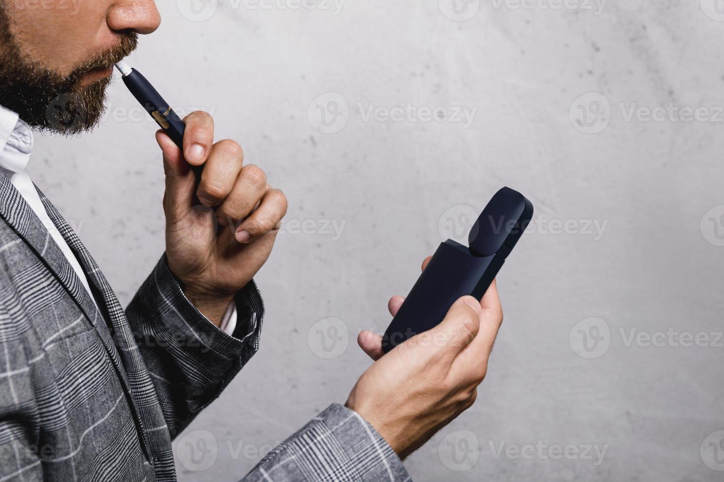 Man with a tobacco heating system in his hands photo