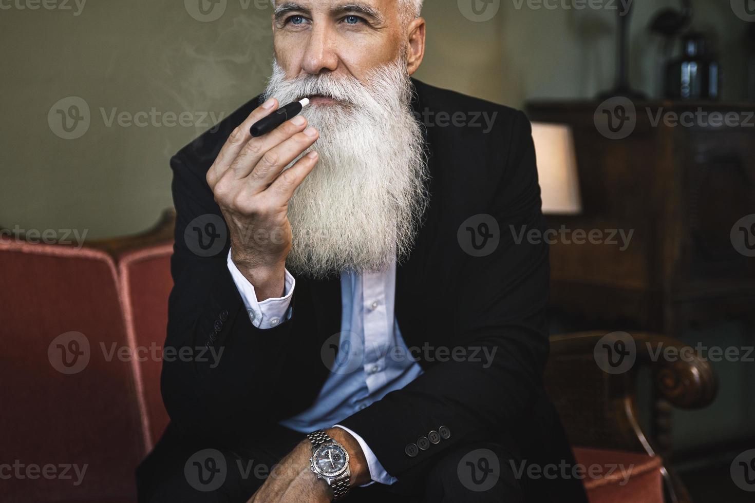 Handsome senior man smoking tobacco heating system photo