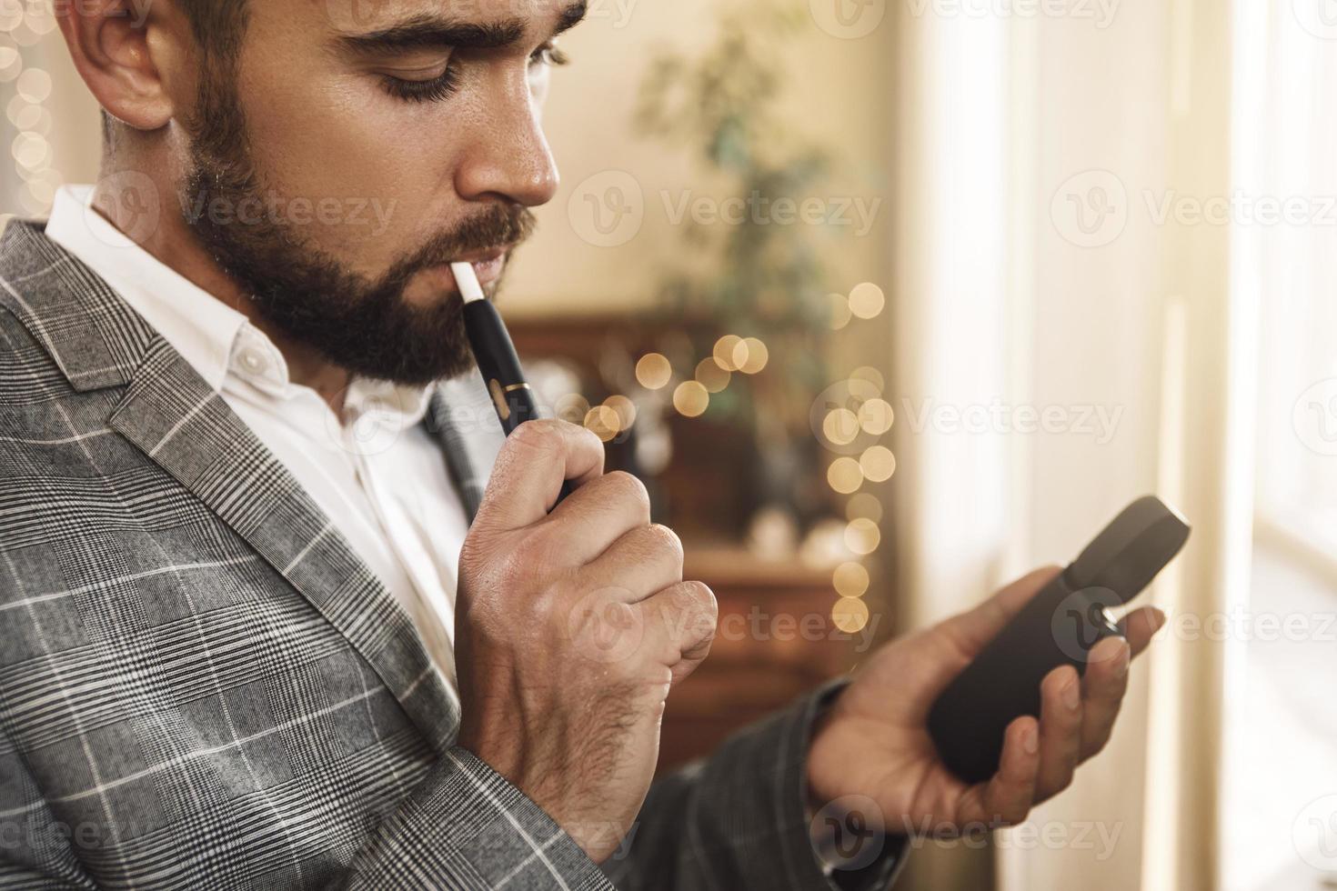 Man with a tobacco heating system in his hands photo