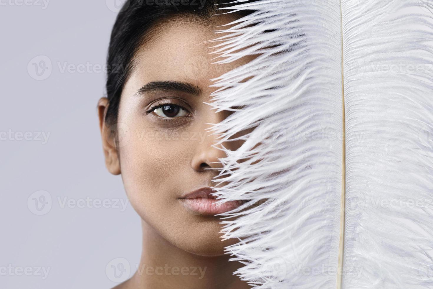 Young and sensual Indian woman with a soft ostrich feather photo