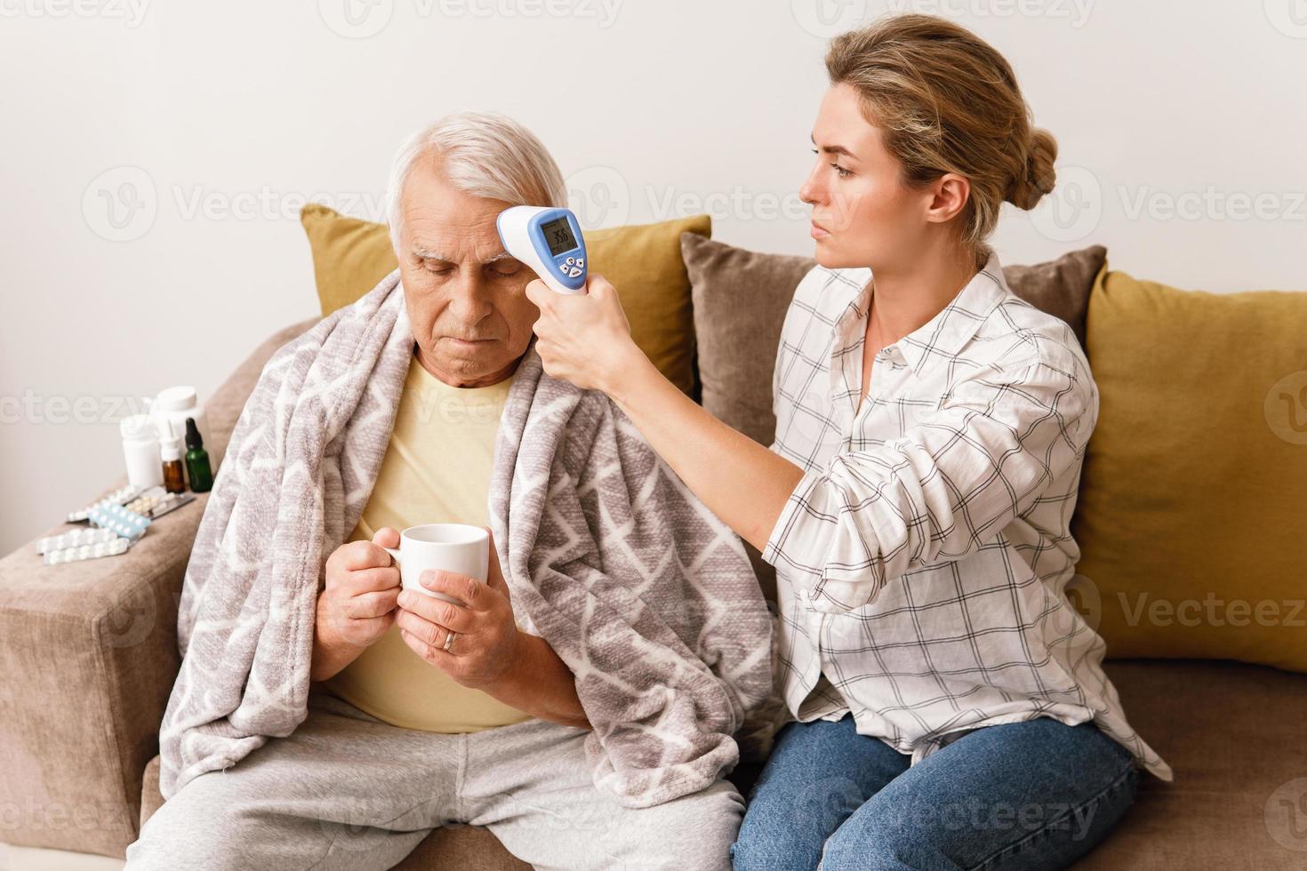 Woman taking care of her elderly grandfather with a cold syptoms photo