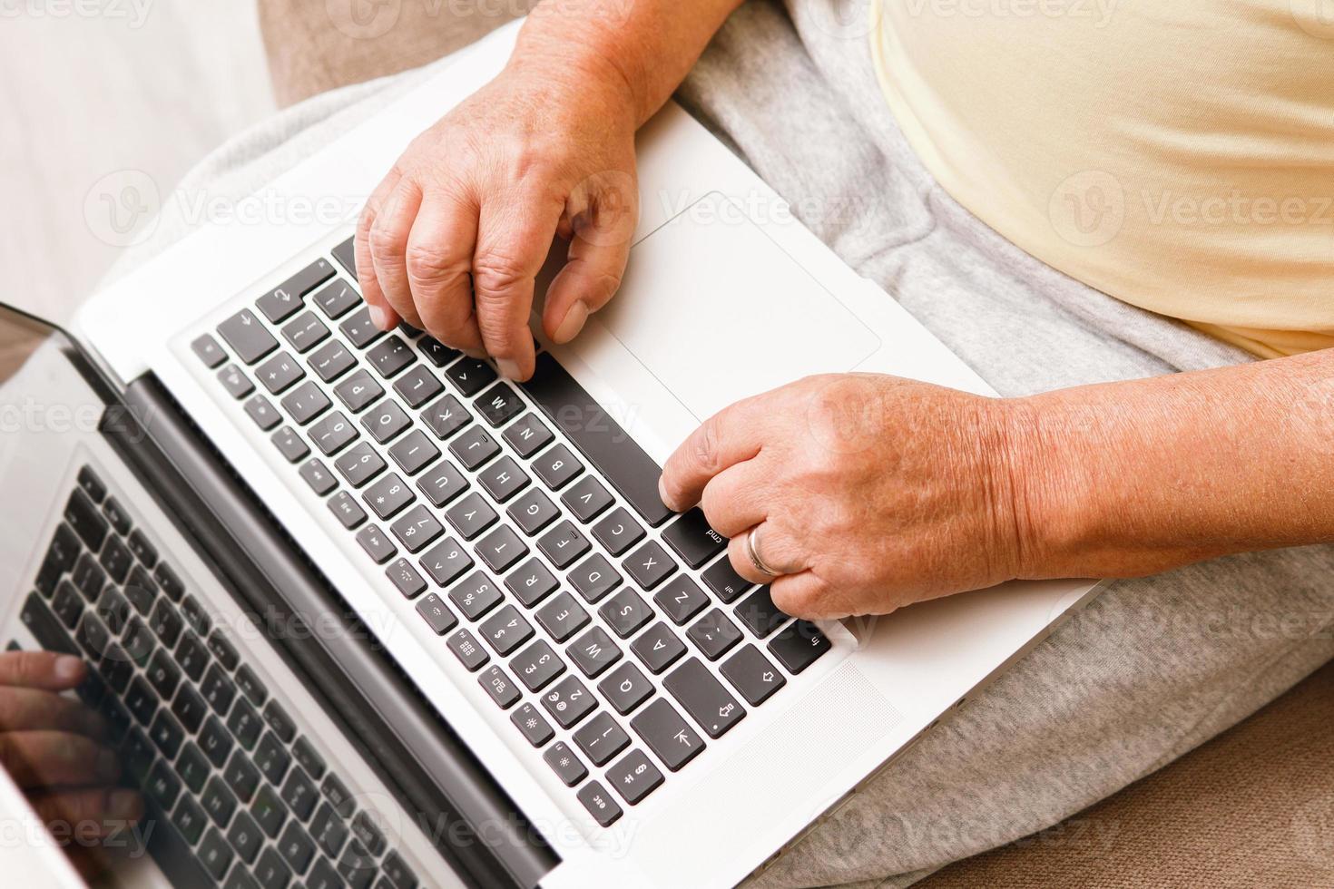 Close-up of elderly man' hands. Senior man is using laptop computer. photo