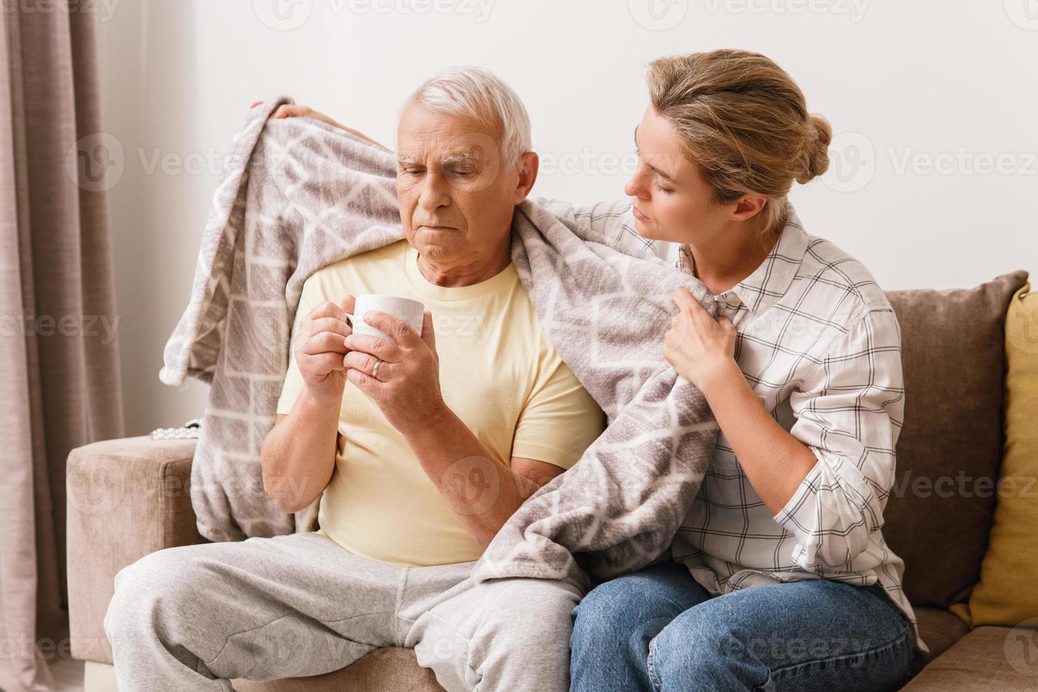 mujer cuidando a su anciano abuelo con síntomas de resfriado foto