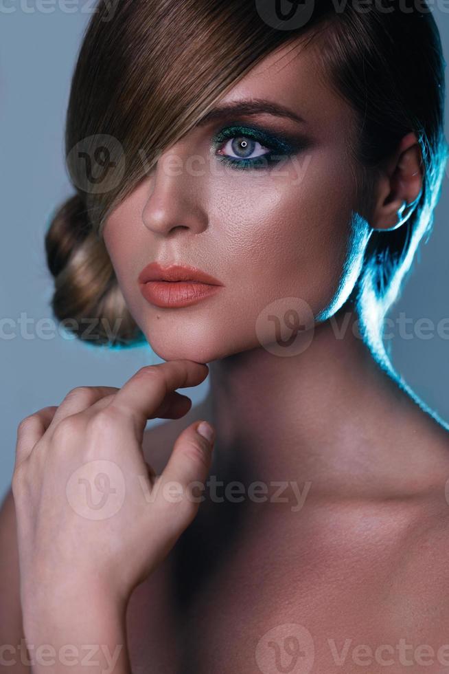 Model in stylish image with sleek hair covering one eye photo