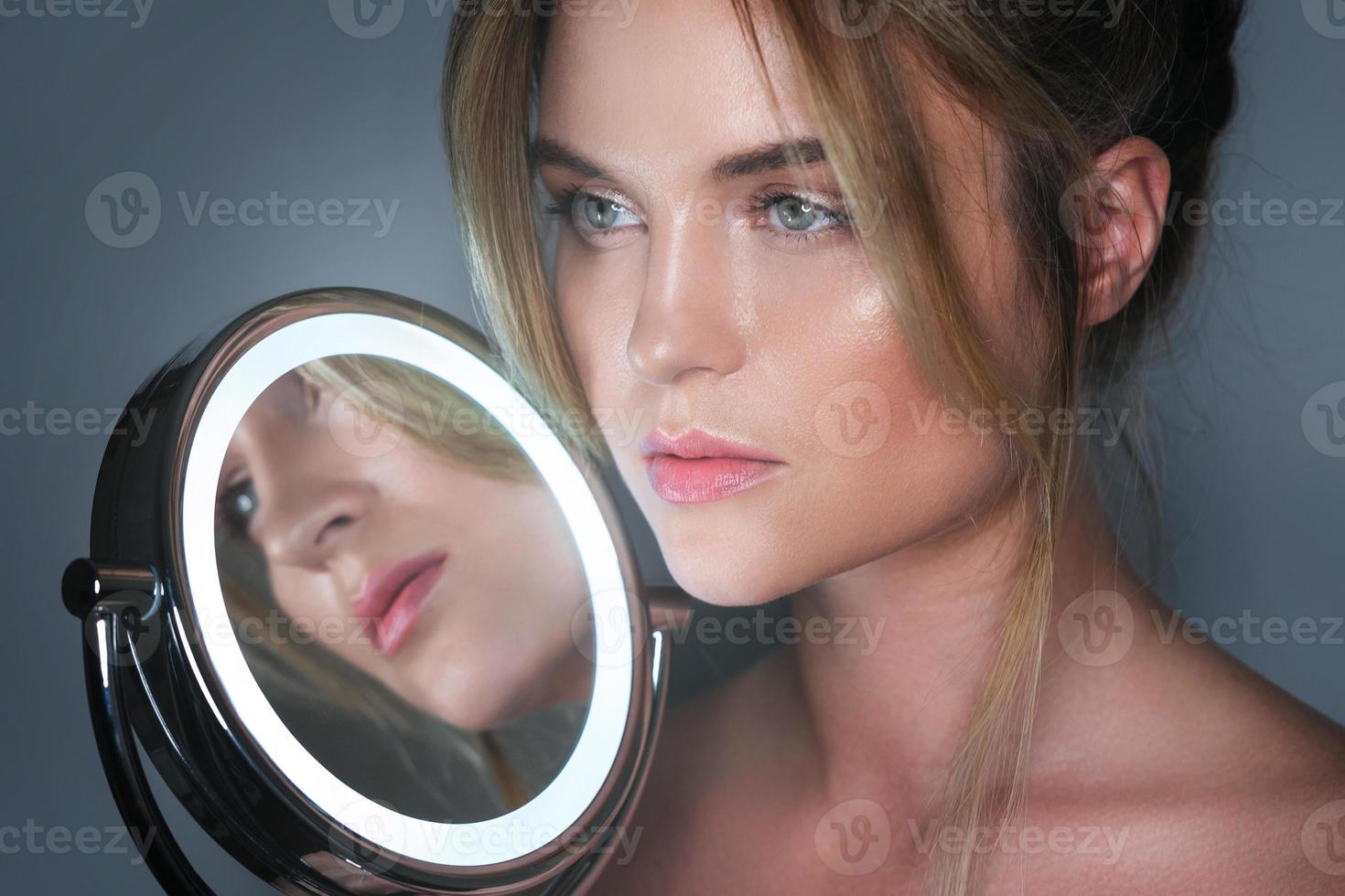 Woman and round mirror with LED light in studio photo