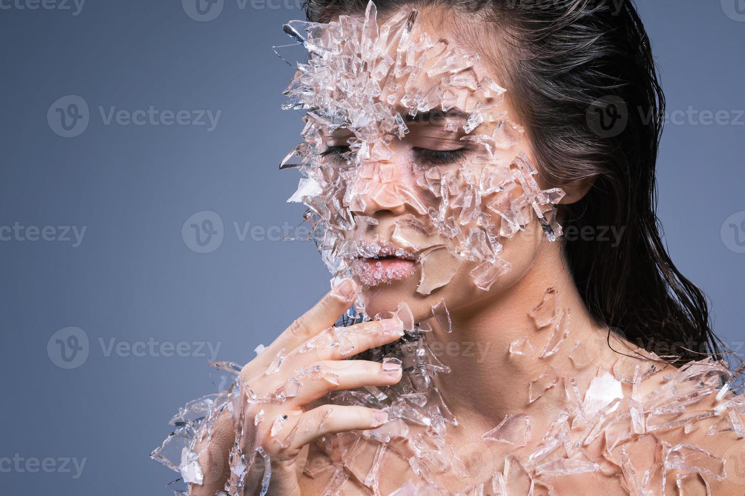 Female face covered with a lot small pieces of glass or ice photo